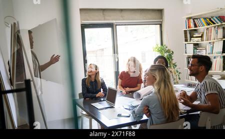 Verschiedene Kollegen aus dem Geschäftsbereich versammeln sich in einem Brainstorming, um Finanzstatistiken gemeinsam zu besprechen Stockfoto