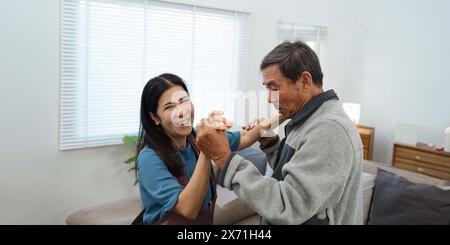 Glückliches Seniorenpaar, das zu Hause in einem hellen Wohnzimmer tanzt. Activity Senior Concept. Stockfoto