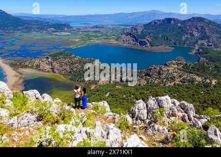 Zwei Personen, die die Aussicht von Tepe Manzara, einem Hügel in der Nähe von Dalyan, mit Blick auf den spektakulären Strand von İztuzu Beach, bewundern Stockfoto