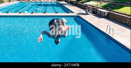 Hamburg, Deutschland. Mai 2024. Ein erster Besucher springt vom 3 Meter hohen Turm. Das Bäderland Hamburg läutet den Beginn der Outdoor-Saison ein und eröffnet das Kaifu-Schwimmbad. Quelle: Markus Scholz/dpa/Alamy Live News Stockfoto