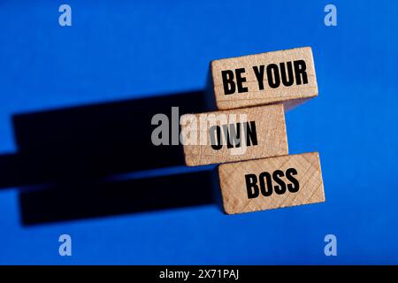 Seien Sie Ihr eigener Boss auf Holzblöcken mit blauem Hintergrund. Konzeptionell sei dein eigenes Boss-Symbol. Kopierbereich. Stockfoto