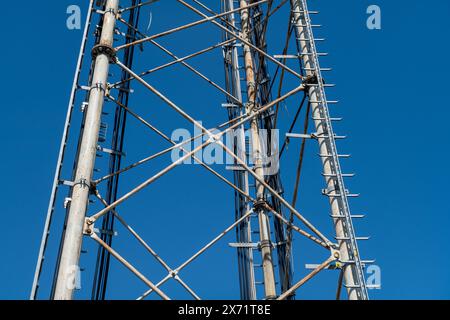 Stahlpylondetails, retikuläre Struktur einer Repeater-Antenne für Funk-, Telefon- und Kommunikationsbänder. Spurstangen und Muttern aus Edelstahl. Stockfoto