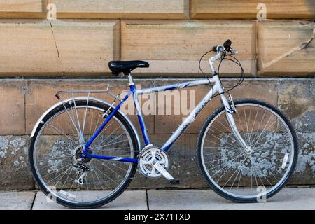 Das Fahrrad lehnt sich an eine Steinmauer. Stockfoto