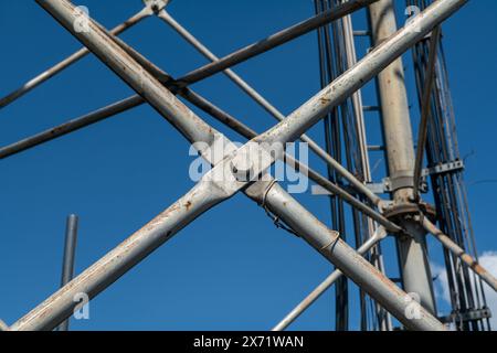 Stahlpylondetails, retikuläre Struktur einer Repeater-Antenne für Funk-, Telefon- und Kommunikationsbänder. Spurstangen und Muttern aus Edelstahl. Stockfoto