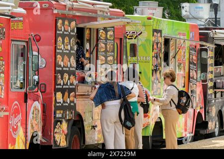 Washington DC, USA - 3. Mai 2024: Menschen, die Fast Food von einem mobilen Food Truck kaufen, der auf einer der Hauptstraßen in Washington DC geparkt ist Stockfoto