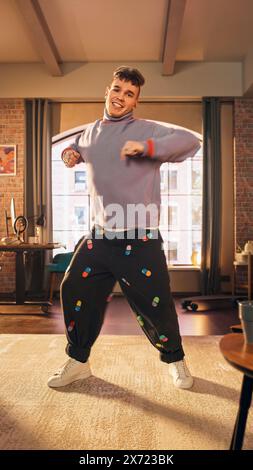 Vertikaler Bildschirm: Handsome Young man nimmt eine Tanzroutine auf Smartphone-Video für soziale Medien auf. Stylischer Mann streamt seine Choreographie Masterclass online im Internet von zu Hause aus. Stockfoto