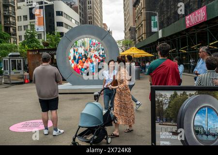 Besucher des Flatiron Plaza in New York begrüßen Dublin, Irland, über das „The Portal“ an seinem Debüt am Mittwoch, den 8. Mai 2024. Die beiden Skulpturen befinden sich in Flatiron Plaza und in der O’Connell Street in Dublin. Die Kunstinstallation wurde vom litauischen Künstler Benediktas Gylys geschaffen und wird 24/7 bis Herbst 2024 ausgestellt. (© Richard B. Levine) Stockfoto