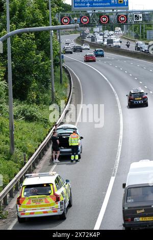 Bristol, Großbritannien. Mai 2024. Ein Pannenfahrzeug auf der Fahrspur der bewirtschafteten Autobahn trägt zu den Problemen der Fahrer auf einer bereits überlasteten Autobahn bei. Ohne eine harte Schulter musste der Fahrer Hilfe rufen und dann auf einem sehr befahrenen Abschnitt der Autobahn sitzen. Ein Verkehrsoffizier kam innerhalb von 10 Minuten an. Der sonnige Wochenendausflug hatte bereits zu Staus geführt, da die Matrix-Schilder die Geschwindigkeit auf 40/50 km/h auf der M5 zwischen den Anschlussstellen 15/16 und 17 in Bristol begrenzen. Highways England meldet Geschwindigkeiten in den 20er Jahren, was an einem sonnigen Freitag normal ist, wenn die Leute nach Süden nach Devon und Cornwall fahren. Gutschrift Stockfoto