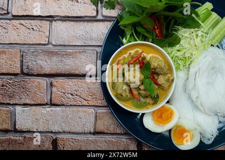 Thai Green Curry mit Schweinebälle und Aubergine, serviert mit Reisnudeln, Gemüse und gekochtem Ei Stockfoto