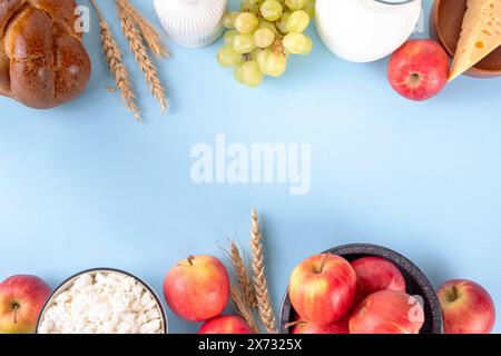 Fröhlicher Shavuot Urlaubshintergrund mit Sommeräpfeln, Weizen, Trauben, Milchprodukten - Käse, Hüttenkäse, Milch oder Sahne, Kopierraum für Text Stockfoto