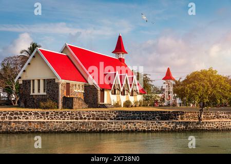 Rote Kirche im Dorf Cap Malheureux auf Mauritius. Notre Dame de Auxiliatrice, ländliche Kirche mit rotem Dach im tropischen Dorf Cap Malheureux auf M Stockfoto