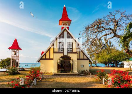 Rote Kirche im Dorf Cap Malheureux auf Mauritius. Notre Dame de Auxiliatrice, ländliche Kirche mit rotem Dach im tropischen Dorf Cap Malheureux auf M Stockfoto