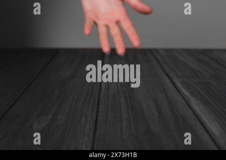 Frau, die Hand über schwarzem Holztisch hält, selektiver Fokus. Leerzeichen für Text Stockfoto