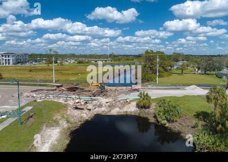 Baumaschinen auf Baustellengelände. Wiederaufbau einer beschädigten Straßenbrücke, die durch den Fluss zerstört wurde, nachdem das Wasser Asphalt weggespült hatte. Neuaufbau Stockfoto