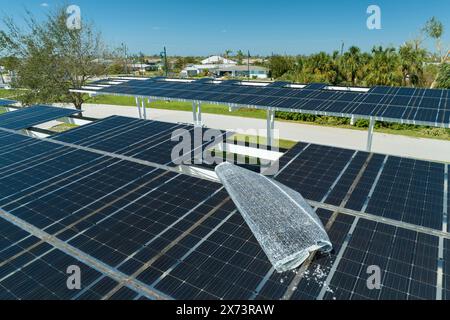 Ausfall der Photovoltaik-Technologie, die in die städtische Infrastruktur integriert ist. Hurrikan-Windschäden an Solarpaneelen, die als Schattendach über dem Parkplatz installiert sind Stockfoto