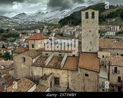 Aus der Vogelperspektive auf das alte mittelalterliche Dorf Castel del Monte mit der schneebedeckten Gran Sasso-Kette dahinter. Castel del Monte, Abruzzen Stockfoto