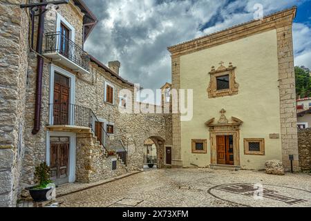 Fassade der Kirche San Rocco mit dem kleinen Platz gleichen Namens und dem Haupttor der Stadtmauer. Castel del Monte, Abruzzen Stockfoto