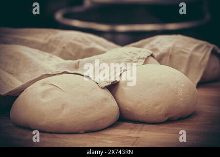 Rohes Brot, teilweise mit einem Leinentuch bedeckte Ballen, bereit zum Backen Stockfoto