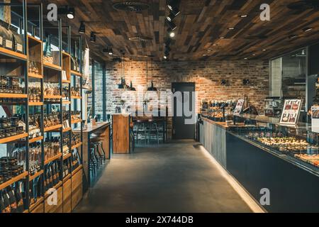 Blick auf eine moderne Bäckerei mit Geschäft und Café, industrieller Stil mit Ziegelwand, Holz und schwarzem Stahl Stockfoto