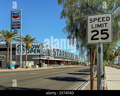 Las Vegas, NV, USA - 12. Mai 2024: Riesiges elektronisches Starbucks-Schild auf der Polaris Ave gegenüber dem Allegiant Stadium unter blauem Himmel mit Chevron-Tankstellen Stockfoto