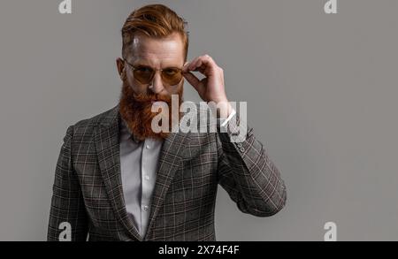 Tuxedo bärtiger Mann in eleganter formeller Herrenbekleidung mit Anzugsjacke und Schleife isoliert auf Grau, Kopierraum Stockfoto