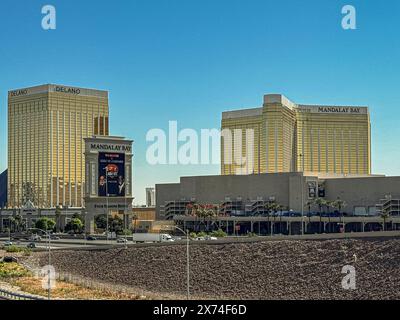 Las Vegas, NV, USA - 12. Mai 2024: Hotels in Delano und Mandalay Bay, hohe und goldene Fassaden unter blauem Himmel. Großes Schild entlang der Interstate 15 Stockfoto