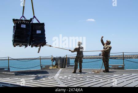 14. Mai 2024 – Ashdod, Israel – Soldaten der US-Armee, die der 7. Transportbrigade (Expeditionary) zugeteilt sind, verwenden ein Seil, um humanitäre Hilfe zu stabilisieren, während sie von einem Kran an Bord der MV Roy P. Benavidez im Hafen von Ashdod, Israel, 14. Mai 2024 angehoben wird. Diese Soldaten unterstützen den Bau des Joint Logistics Over-the-Shore-Systems vor der Küste des Gazastreifens. Auf Ersuchen der Agentur der Vereinigten Staaten für internationale Entwicklung wird der vorläufige Pier, die sogenannte Joint Logistics Over-the-Shore Capability, der humanitären Gemeinschaft bei der Bereitstellung internationaler humanitärer Hilfe helfen Stockfoto