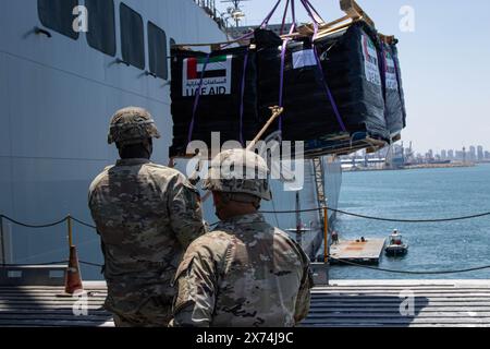 14. Mai 2024 – Ashdod, Israel – Soldaten der US-Armee, die der 7. Transportbrigade (Expeditionary) zugeteilt sind, verwenden ein Seil, um humanitäre Hilfe zu stabilisieren, während sie von einem Kran an Bord der MV Roy P. Benavidez im Hafen von Ashdod, Israel, 14. Mai 2024 angehoben wird. Diese Soldaten unterstützen den Bau des Joint Logistics Over-the-Shore-Systems vor der Küste des Gazastreifens. Auf Ersuchen der Agentur der Vereinigten Staaten für internationale Entwicklung wird der vorläufige Pier, die sogenannte Joint Logistics Over-the-Shore Capability, der humanitären Gemeinschaft bei der Bereitstellung internationaler humanitärer Hilfe helfen Stockfoto