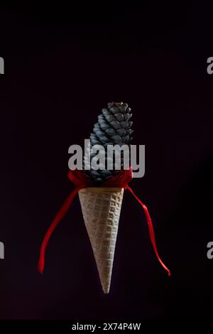 Ein Eiskegel hängt mit einem roten Band in der Luft Stockfoto