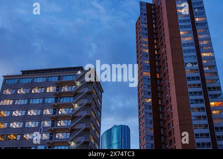 Zwei beleuchtete Wolkenkratzer vor einem bewölkten Abendhimmel, kleiner Hafen in einer großen Stadt mit Leuchtturm und modernen Häusern, Rotterdam, Niederlande Stockfoto