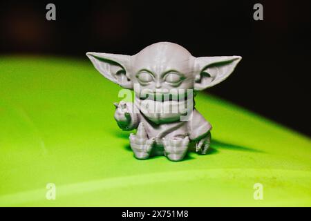 Madrid, Spanien 7. Mai 2024 DIN Grogu, Star Wars Spielzeugheld aus recyceltem Kunststoff isoliert auf grünem Hintergrund. Happy Baby Yoda aus der Disney-Serie. Stockfoto