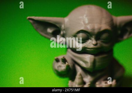 Madrid, Spanien 7. Mai 2024 DIN Grogu, Star Wars Spielzeugheld aus recyceltem Kunststoff isoliert auf grünem Hintergrund. Happy Baby Yoda aus der Disney-Serie. Stockfoto