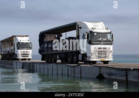 Mittelmeer, Israel. Mai 2024. LKWs, die mit humanitärer Hilfe aus den Vereinigten Arabischen Emiraten und USAID beladen sind, überqueren am 17. Mai 2024 den neu eröffneten Trident Floating Pier am Mittelmeer in Gaza, palästinensisches Gebiet. Der schwimmende Pier wird dazu genutzt, humanitäre Hilfe direkt von Schiffen an Land für das palästinensische Volk in Gaza zu bringen. Gutschrift: SSgt. Malcolm Cohens-Ashley/US Army Photo/Alamy Live News Stockfoto