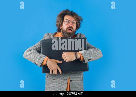 Porträt eines verwirrten Geschäftsmannes im Anzug mit Aktenkoffer. Verblüffter bärtiger Mann in Brille mit Attache-Fall. Schicker, schockierter Geschäftsmann Stockfoto