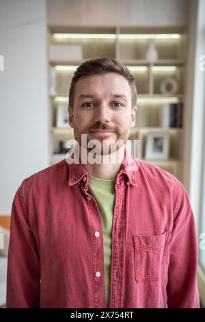 Porträt ruhig freundlich lächelnd positiver Mann mittleren Alters mit Stoppeln, der auf den Kamerahintergrund blickt. Stockfoto