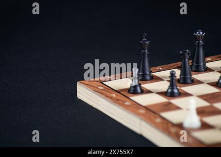 Schachbrett mit hellen und dunklen Teilen. Spielkonzept. Brettspiel. Hobby. Schach auf dem Spielfeld für ein Spiel auf schwarzem Hintergrund. Stockfoto