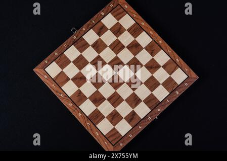 Leeres Holzbrett eines Schachspiels, fotografiert von oben auf schwarzem Hintergrund. Stockfoto