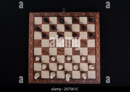 Schachbrett mit Stücken. Spielkonzept. Brettspiel. Hobby. Von oben fotografiert. Spiel auf schwarzem Hintergrund. Stockfoto