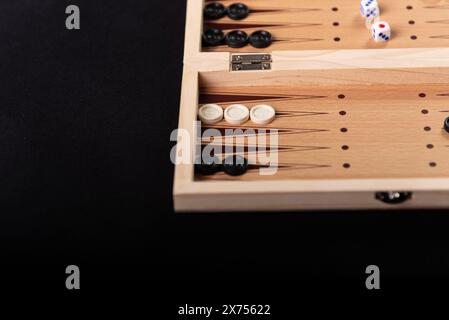 Traditionelles Backgammon-Spiel. Brett mit Backgammon Spielstücken auf schwarzem Hintergrund. Stockfoto