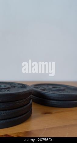 Schwere Kurzhanteln auf Holzoberfläche, Fitnessgeräte Stockfoto