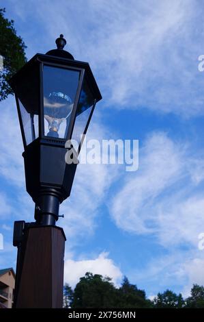 Schwarzer Lampenpfosten gegen einen blauen Himmel Stockfoto