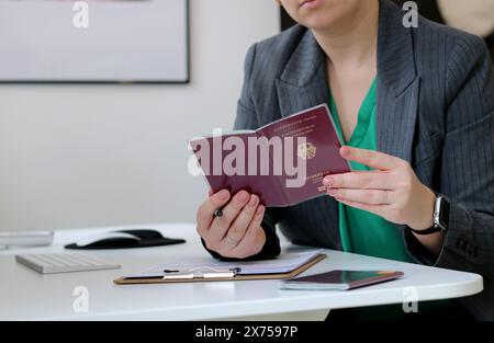 Nahaufnahme einer kaukasierin mit deutschem Pass und Ausfüllen eines Visumantrags im Büro Stockfoto