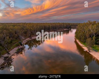 Aus der Vogelperspektive eines breiten Binnenflusses unter einem farbenfrohen Sonnenuntergangshimmel auf dem Murray River in der Nähe von Cobram in Victoria, Australien Stockfoto