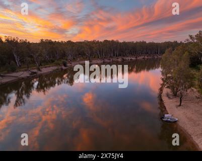 Aus der Vogelperspektive eines breiten Binnenflusses unter einem farbenfrohen Sonnenuntergangshimmel auf dem Murray River in der Nähe von Cobram in Victoria, Australien Stockfoto