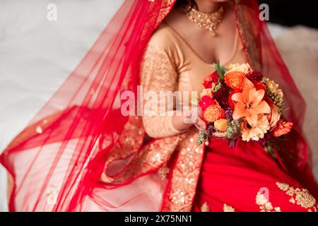 Hindu, Hochzeit und Frau mit Blumenstrauß in der Hand für traditionelle, Heirat und Kleidung. Henna, elegantes Kleid und Braut mit Blumenstrauß Stockfoto