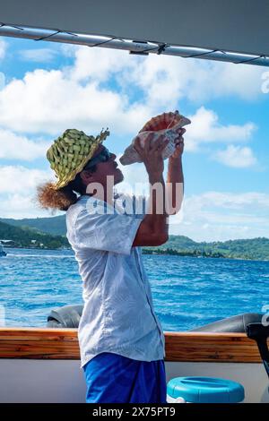 Polynesischer Mann, der in einer Muschel bläst, Bora Bora, Gesellschaftsinseln, Französisch-Polynesien Stockfoto