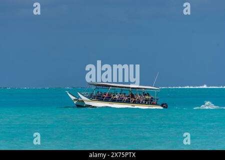 Touristen auf einer Tour in einem typischen polynesischen Kanu über die Lagune und ihr türkisfarbenes Wasser, Bora Bora, Gesellschaftsinseln, Französisch-Polynesien Stockfoto