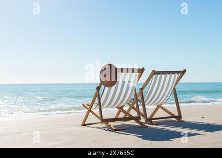 Am Strand zwei leere Stühle zum Meer, was auf Entspannung hindeutet Stockfoto