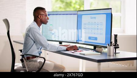 African Man Füllen Online-Umfrage-Formular Auf Laptop-Computer Stockfoto