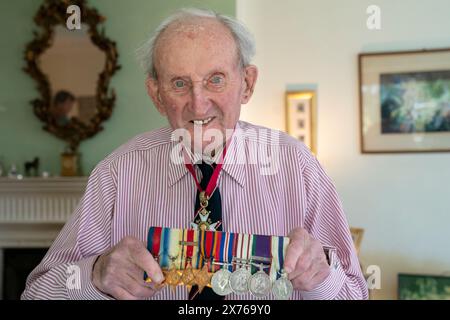 Vizeadmiral Sir Thomas Baird aus Symington in Ayrshire hält seine Medaillen, während er seinen 100. Geburtstag feiert. Sir Thomas nahm 41 Jahre in der Marine an den arktischen Konvois Teil, die von Großbritannien zu Häfen im äußersten Norden der Sowjetunion segelten, als eine Geste der Unterstützung der Alliierten, als Hitler gegen einen mit Stalin geschlossenen nichtangriffvertrag verstieß. Bilddatum: Freitag, 17. Mai 2024. Stockfoto